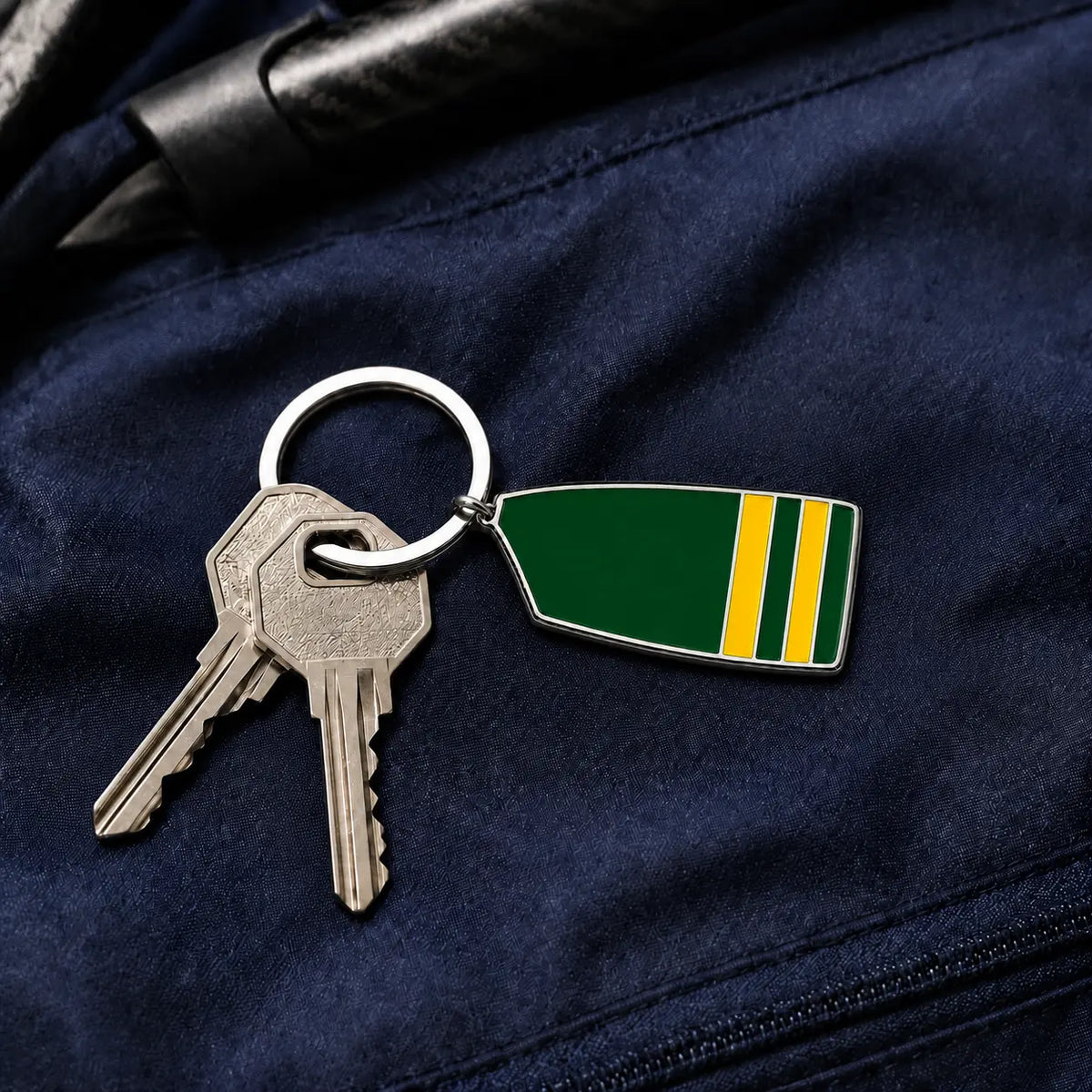 Custom rowing oar keychain attached to keys on a navy rowing bag